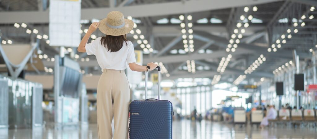 Young woman tourist at international airport terminal. Time to travel, trip and vacation. Gear Tech Tools